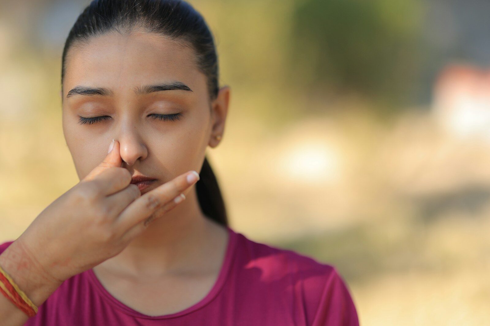 Photo by Charanjeet Dhiman Young woman practicing alternate nostril breathing outdoors